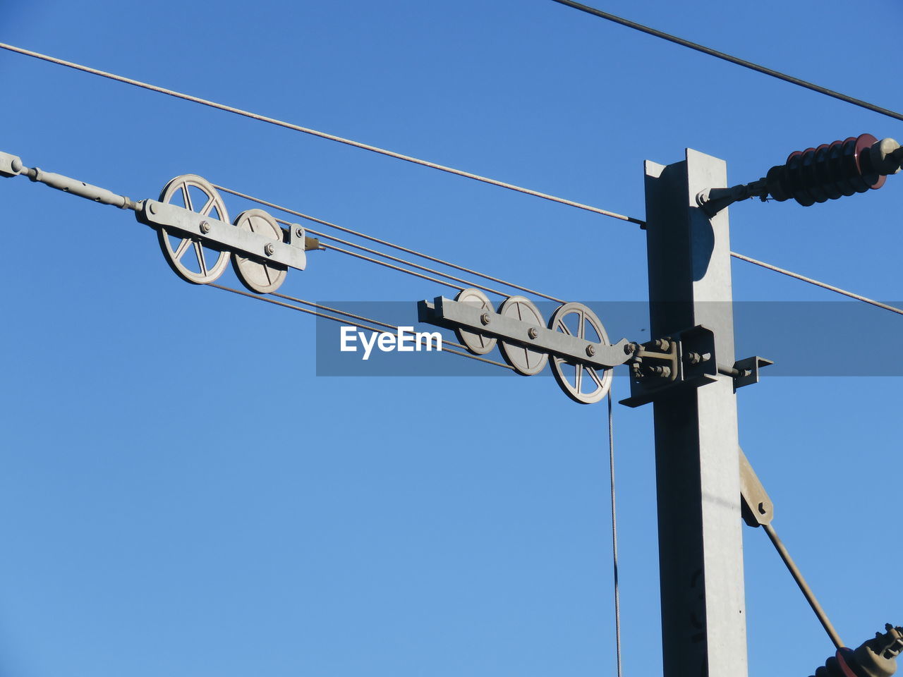 LOW ANGLE VIEW OF ELECTRICITY PYLON AGAINST CLEAR SKY