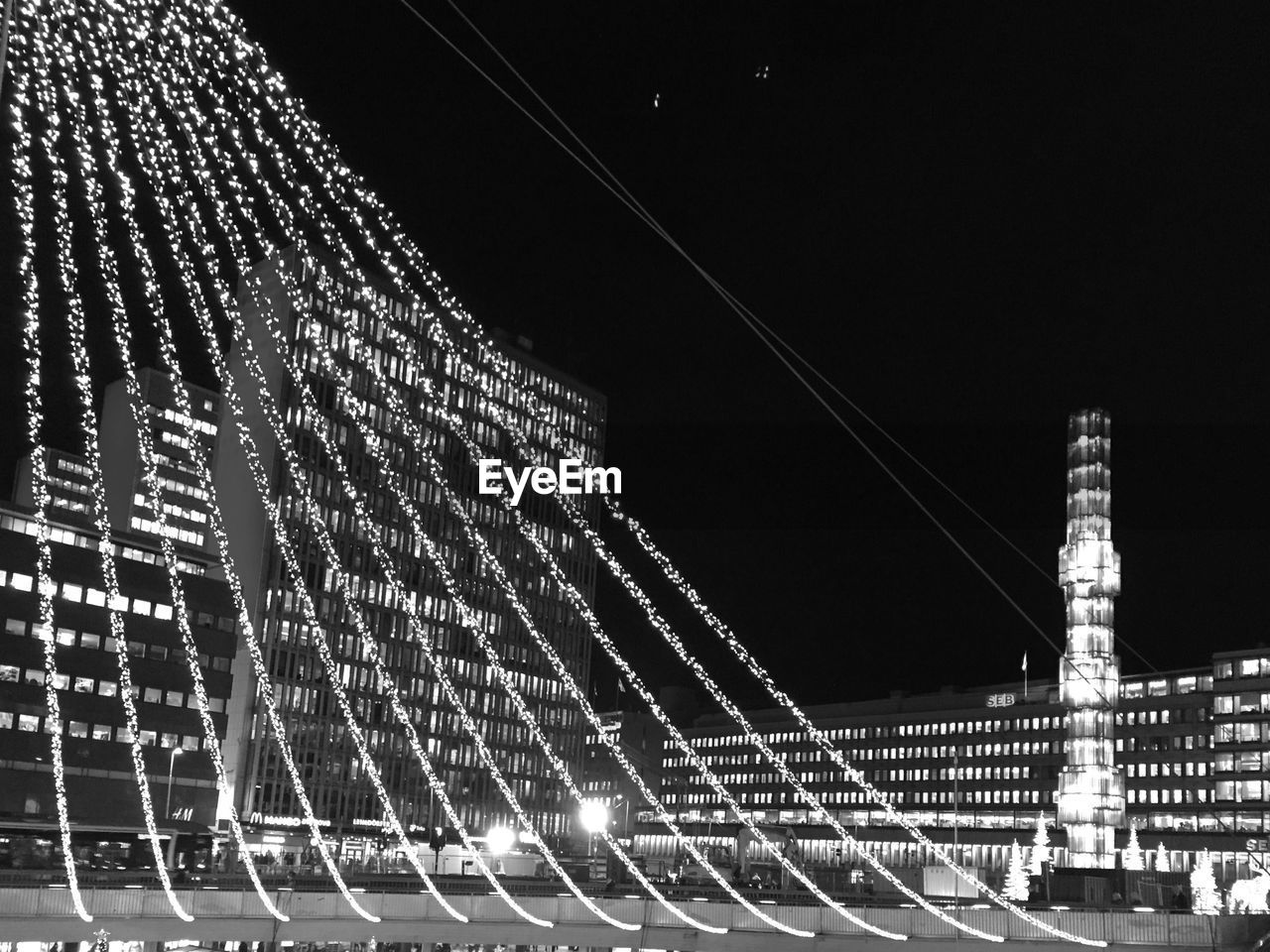 LOW ANGLE VIEW OF ILLUMINATED BUILDINGS AT NIGHT