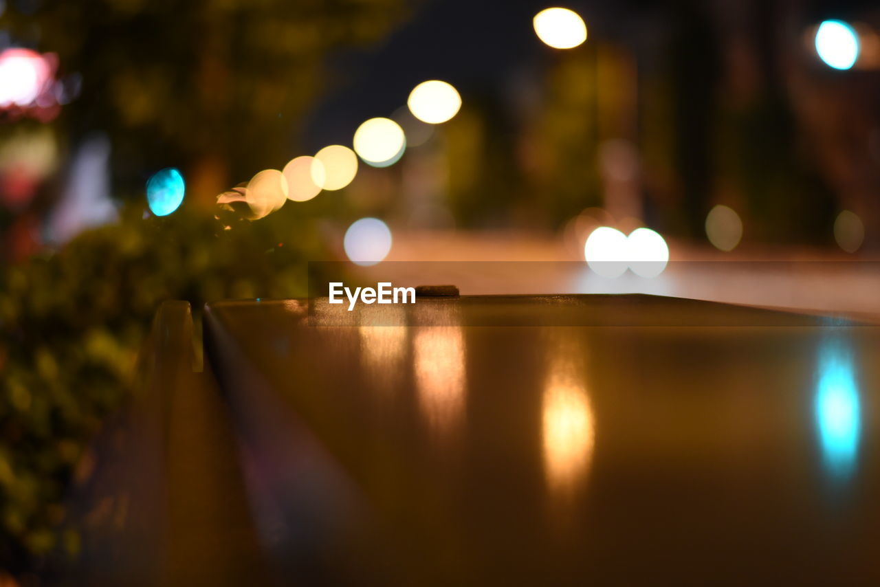 Reflection of illuminated street lights on railing
