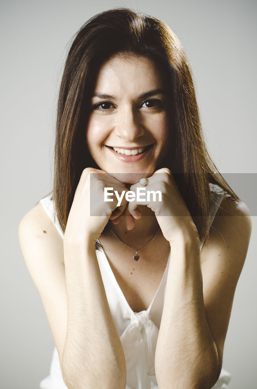 Portrait of smiling woman against white background