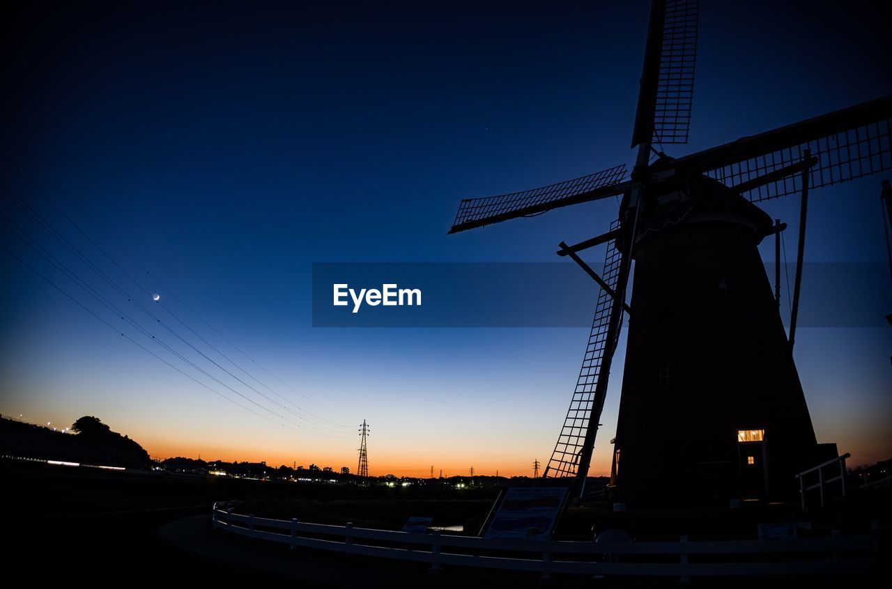 LOW ANGLE VIEW OF TRADITIONAL WINDMILL AGAINST CLEAR BLUE SKY