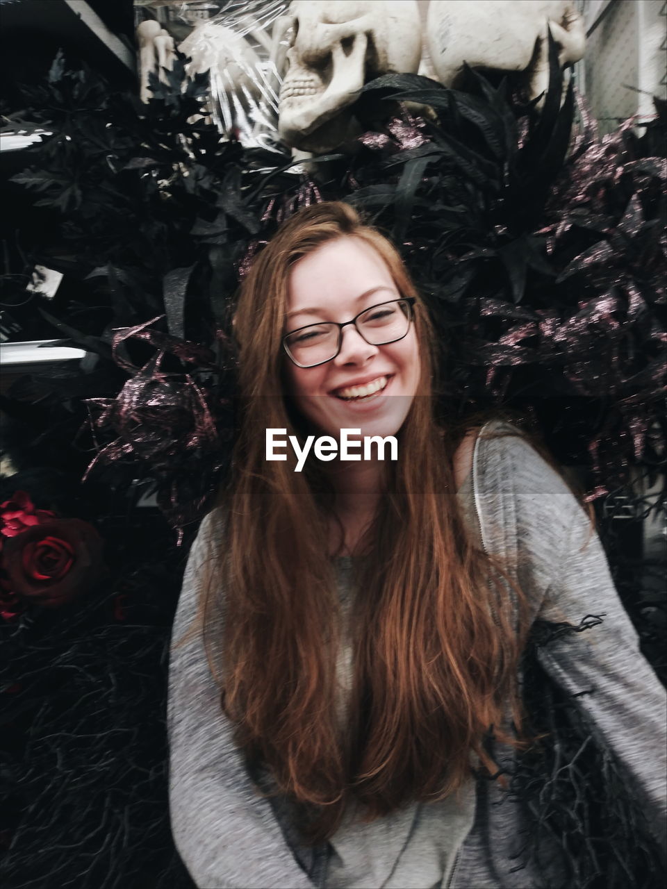 PORTRAIT OF SMILING YOUNG WOMAN AT HOME