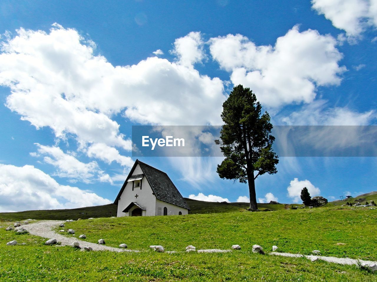 BUILT STRUCTURE ON FIELD BY BUILDINGS AGAINST SKY