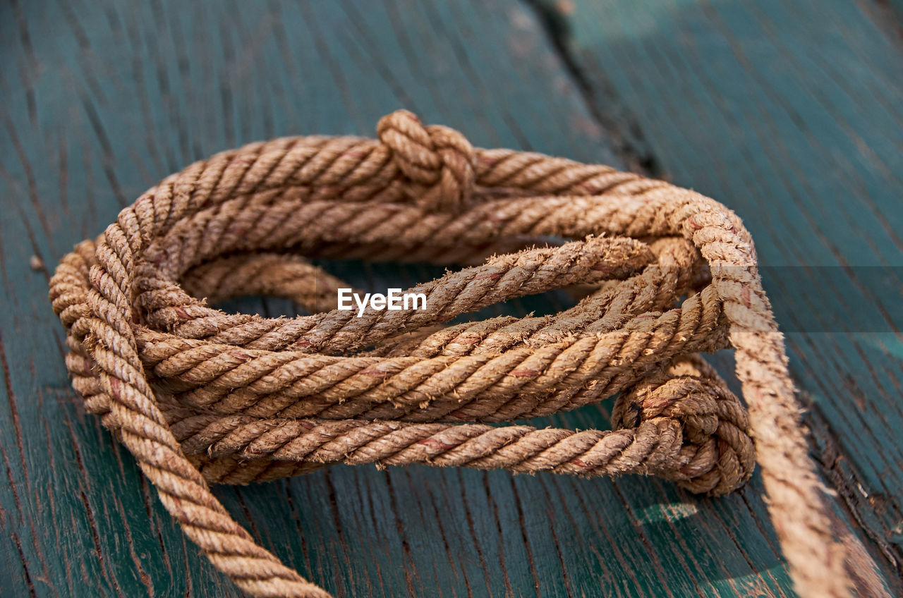 Close-up of rope on wooden plank