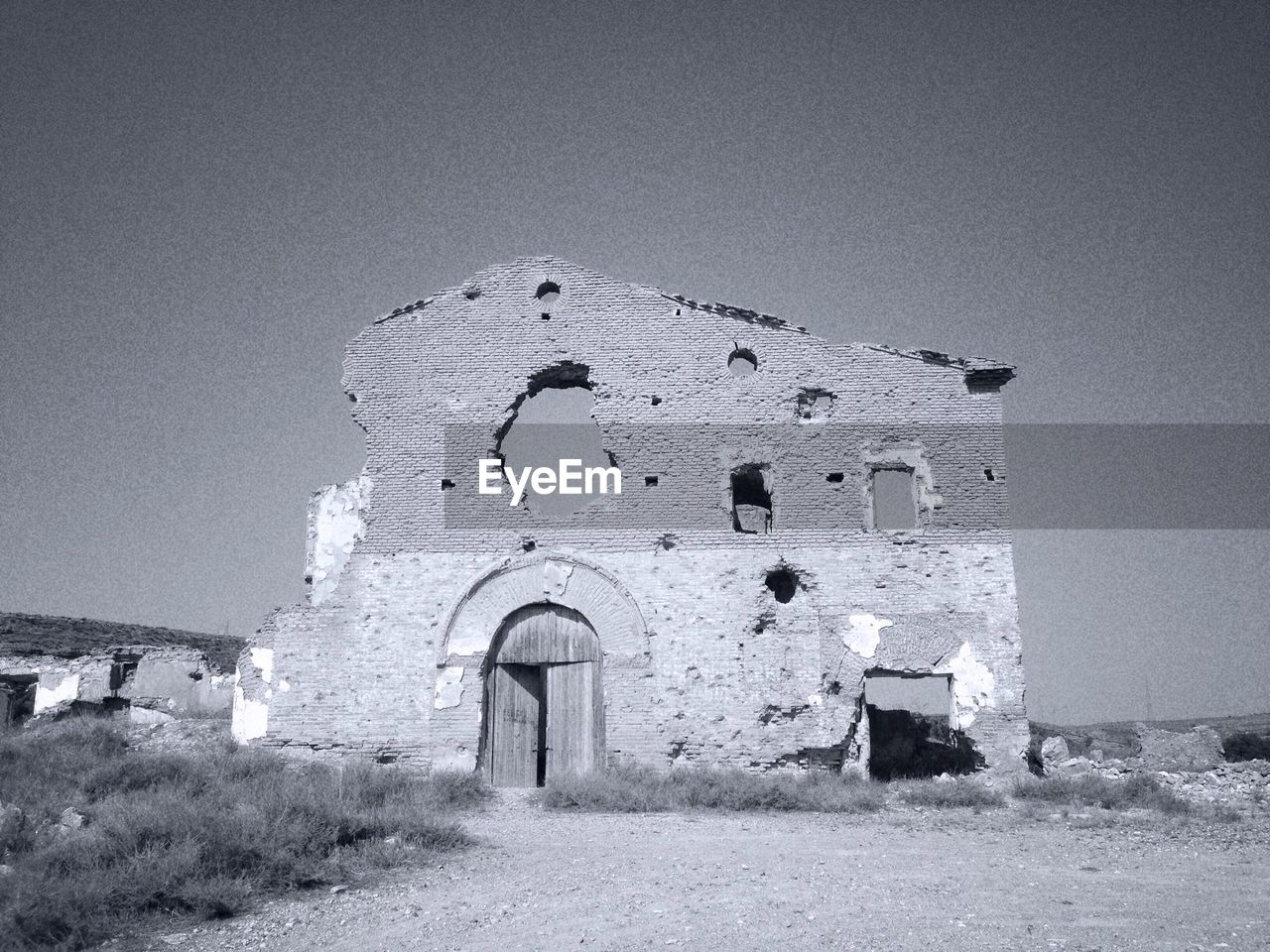 Exterior of damaged house against clear sky