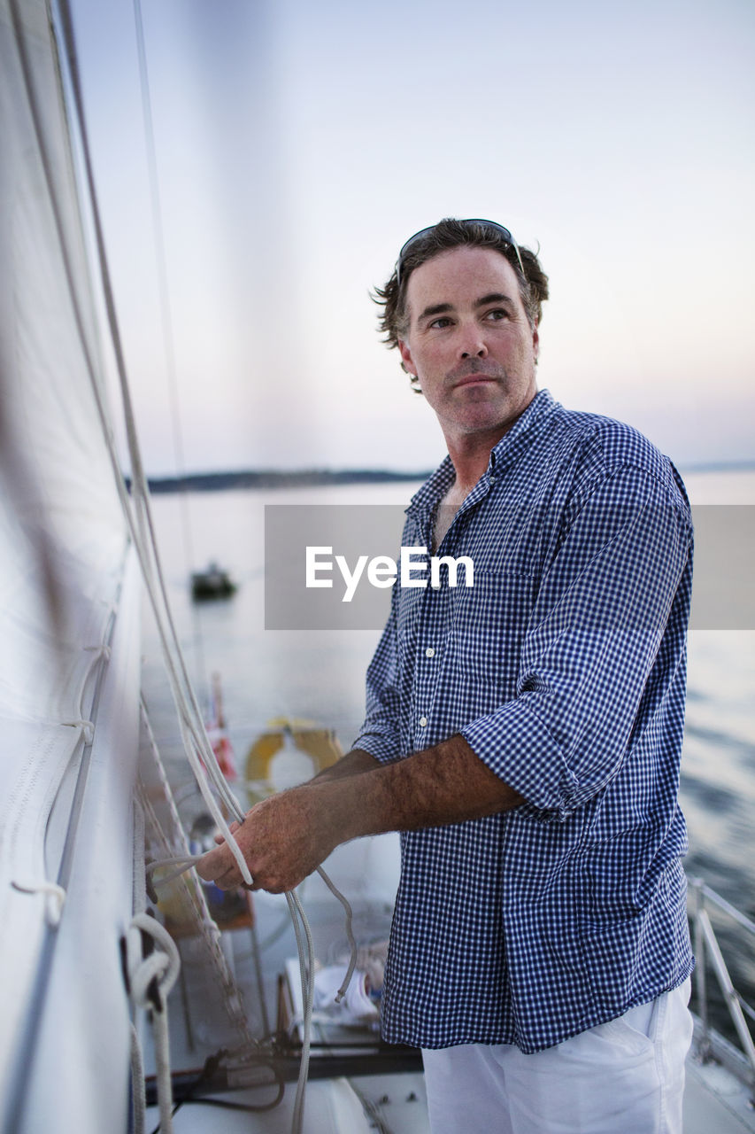 Man looking away while standing in yacht deck