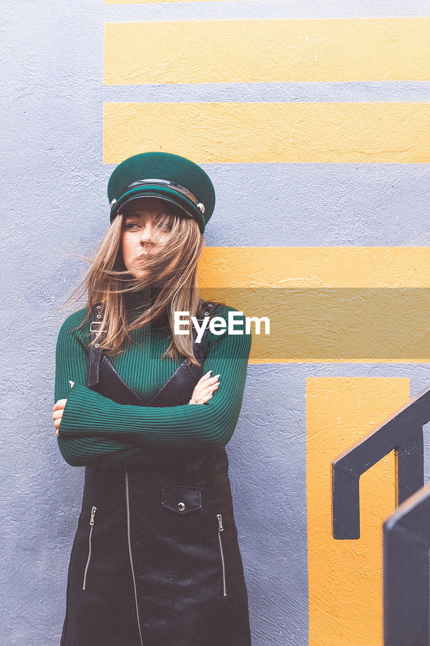 Portrait of woman standing against wall