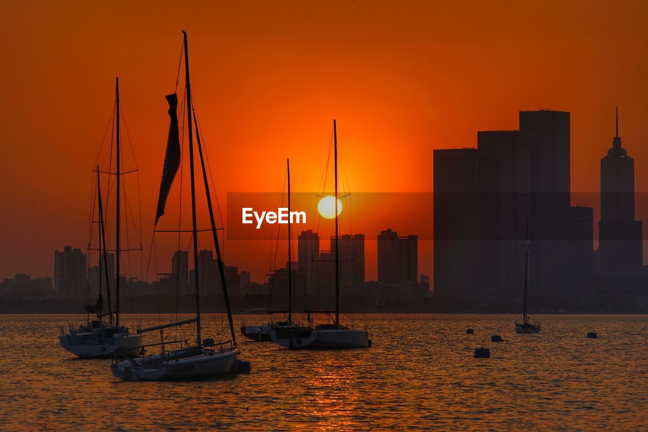 SAILBOATS IN SEA AGAINST SUNSET SKY