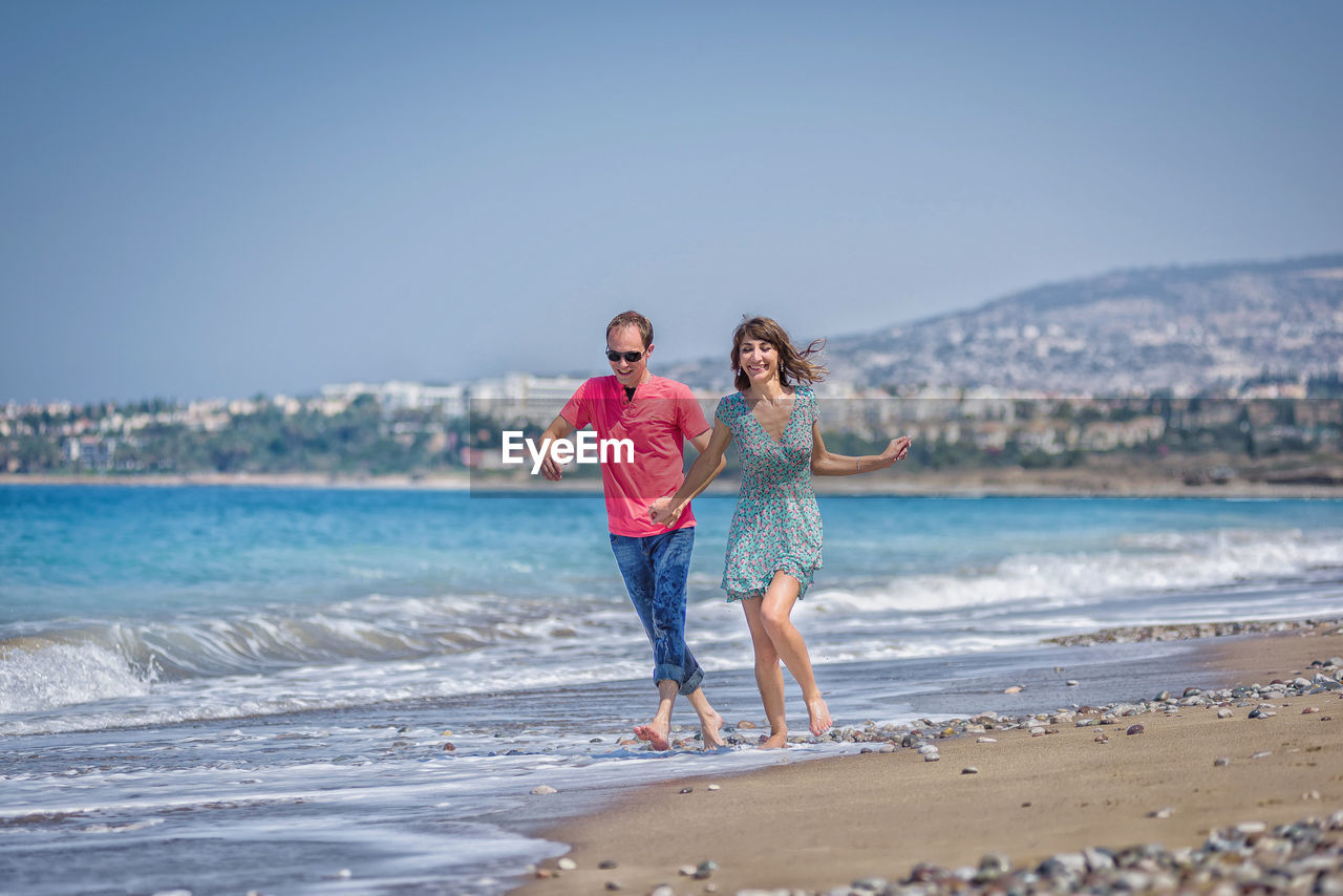 Smiling couple running at beach