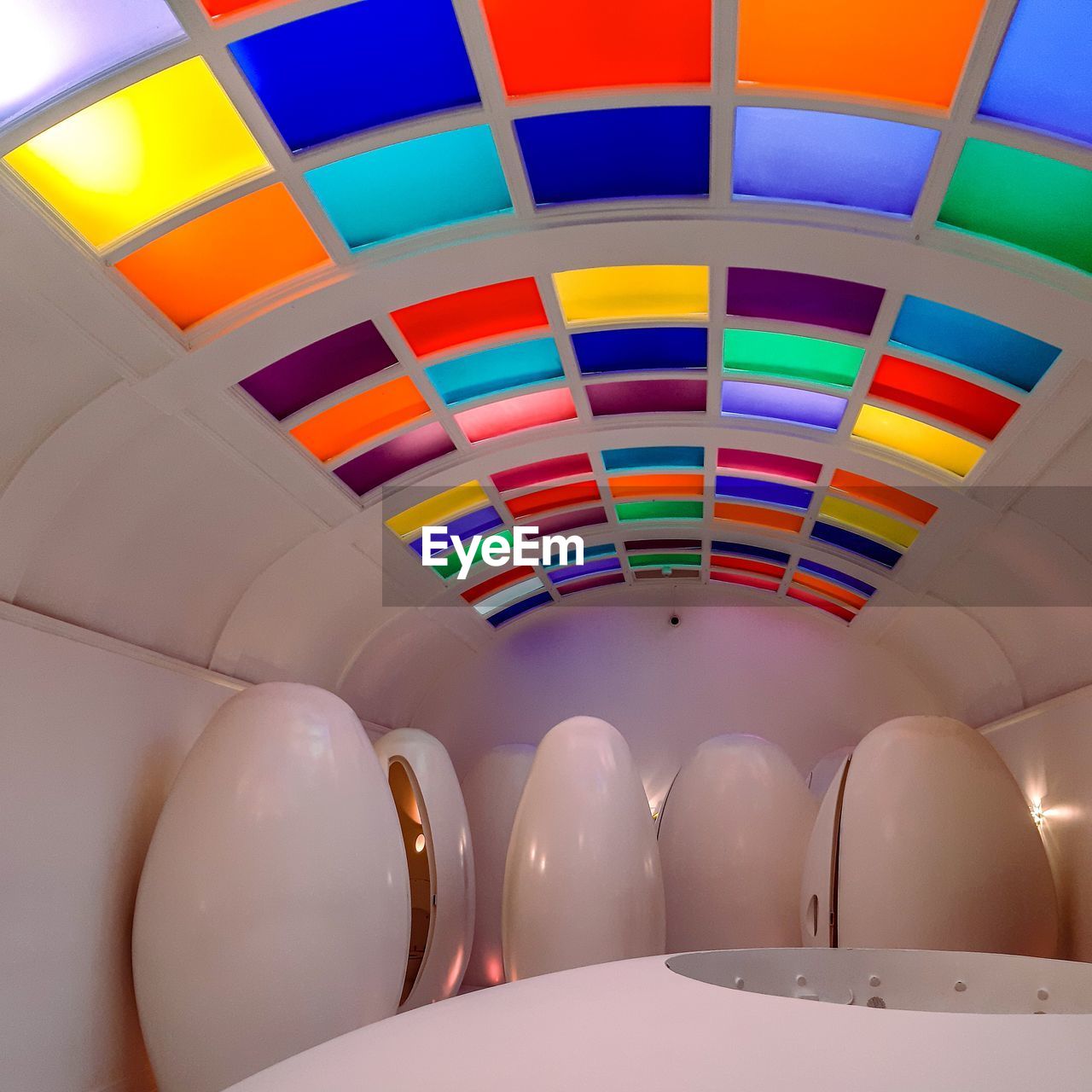 LOW ANGLE VIEW OF MULTI COLORED BALLOONS ON TABLE IN CEILING