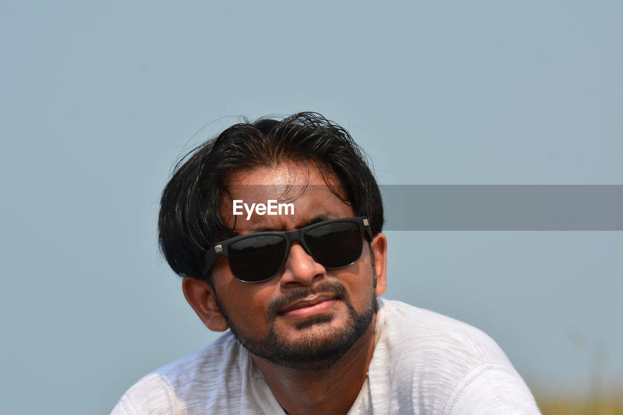 Portrait of man wearing sunglasses against clear sky