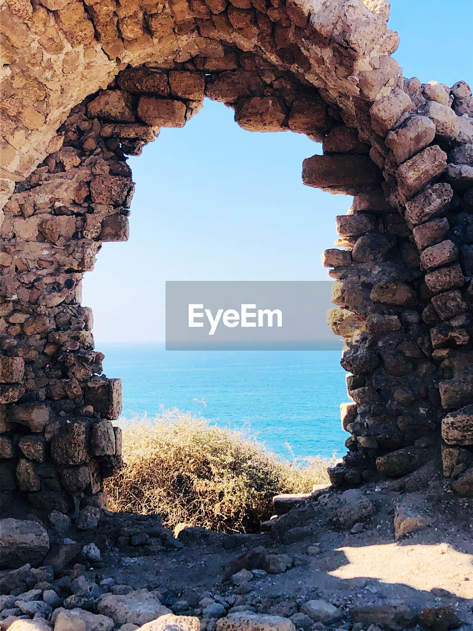 Rock formations by sea against clear sky