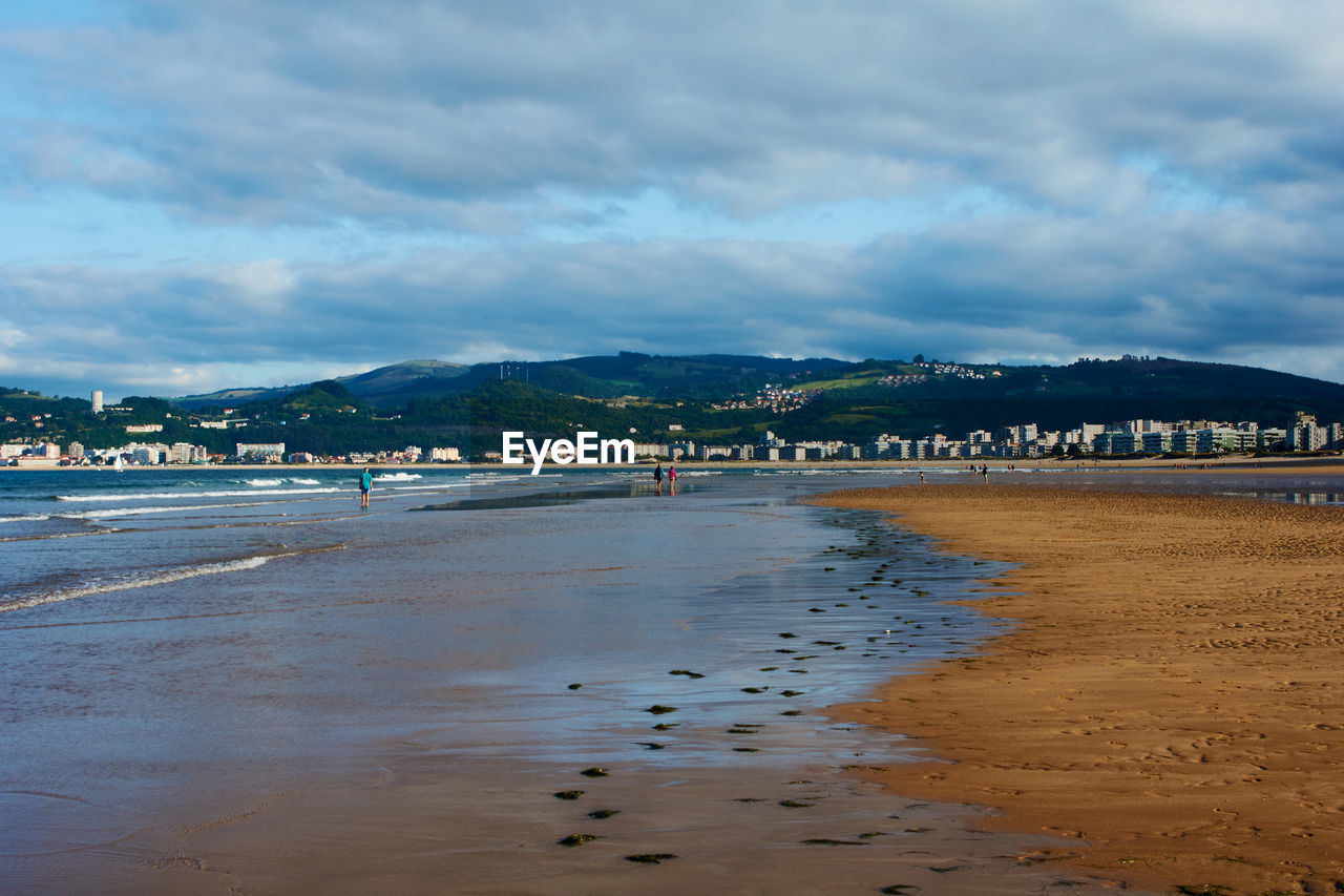 SCENIC VIEW OF BEACH AGAINST CLOUDY SKY