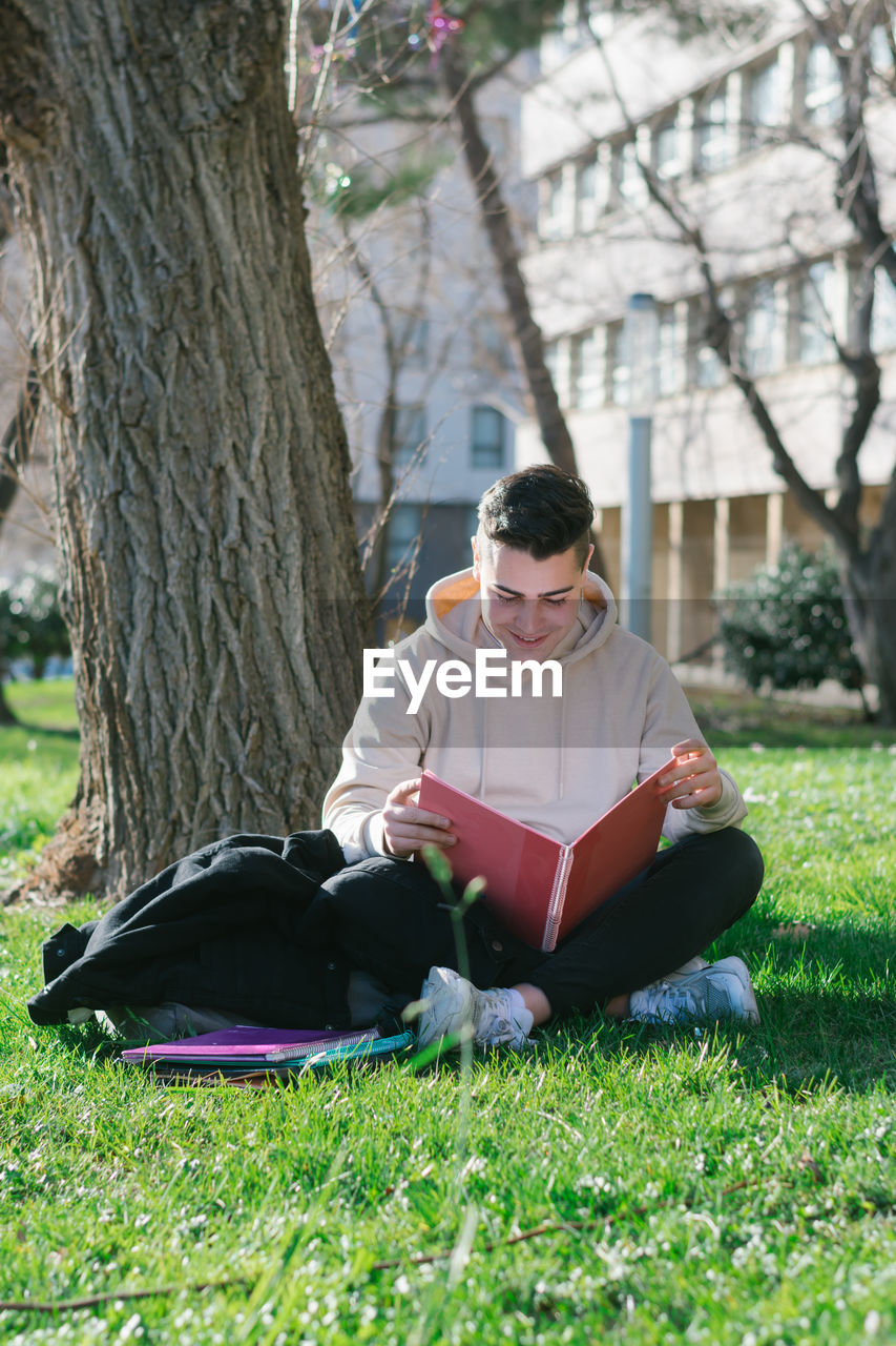 Full length of young man reading book in park