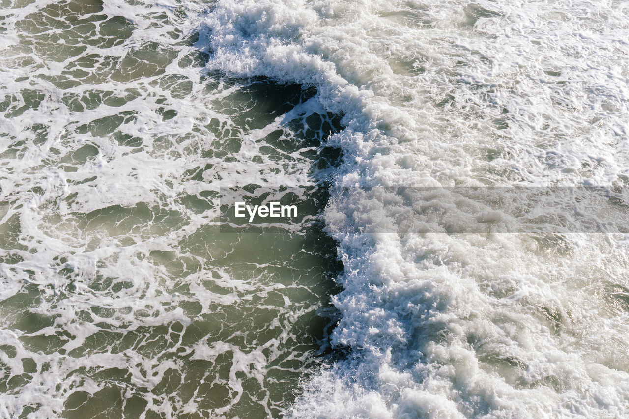 High angle view of water flowing in sea.