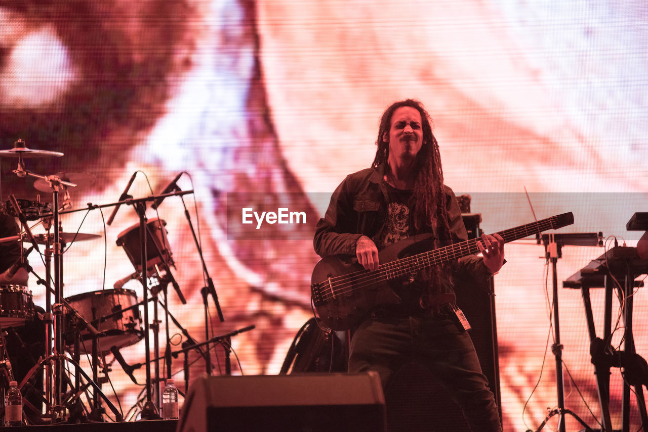 FULL LENGTH OF A MAN PLAYING GUITAR AT MUSIC CONCERT