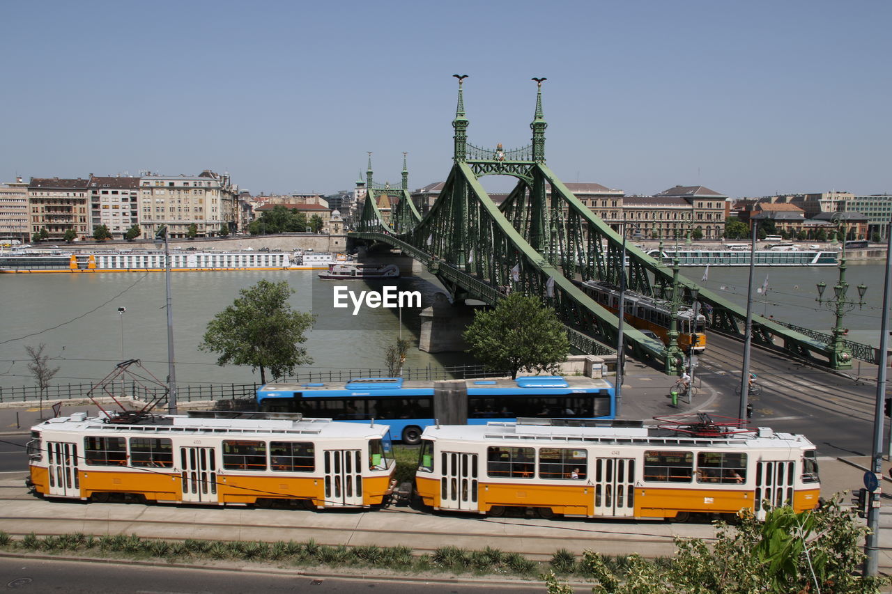 Train on bridge against sky in city