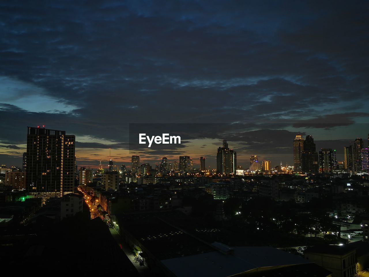 ILLUMINATED CITYSCAPE AGAINST SKY