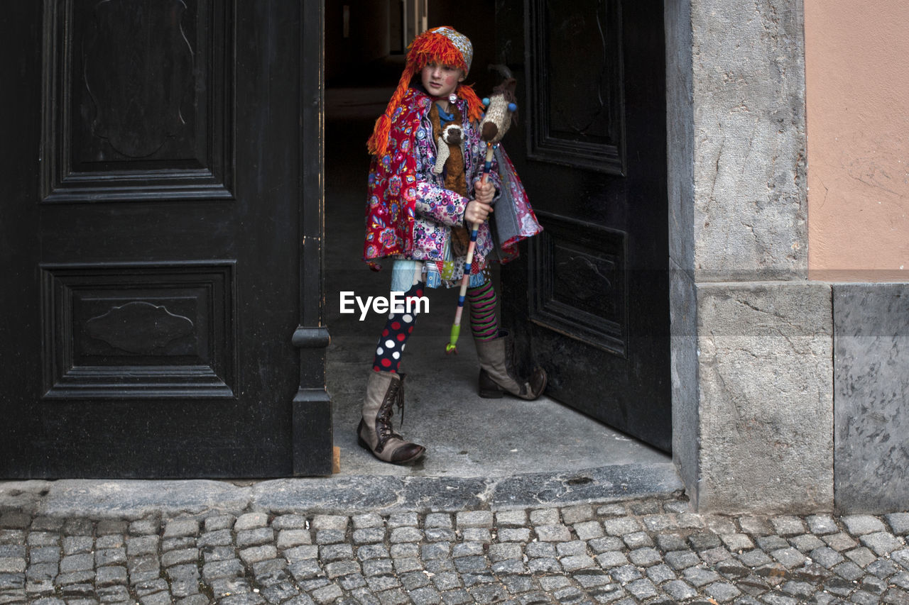 WOMAN STANDING ON STREET BY BUILDING