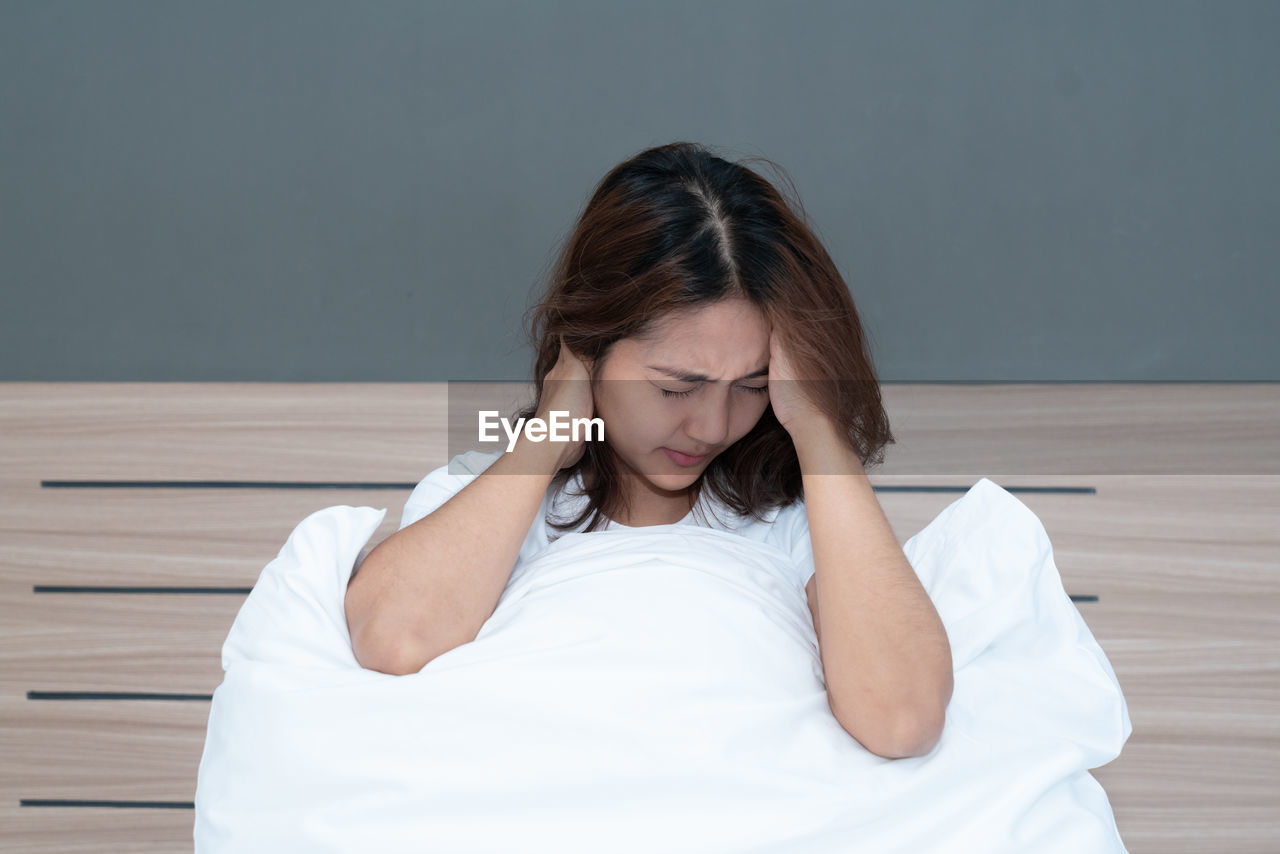 WOMAN SITTING ON BED