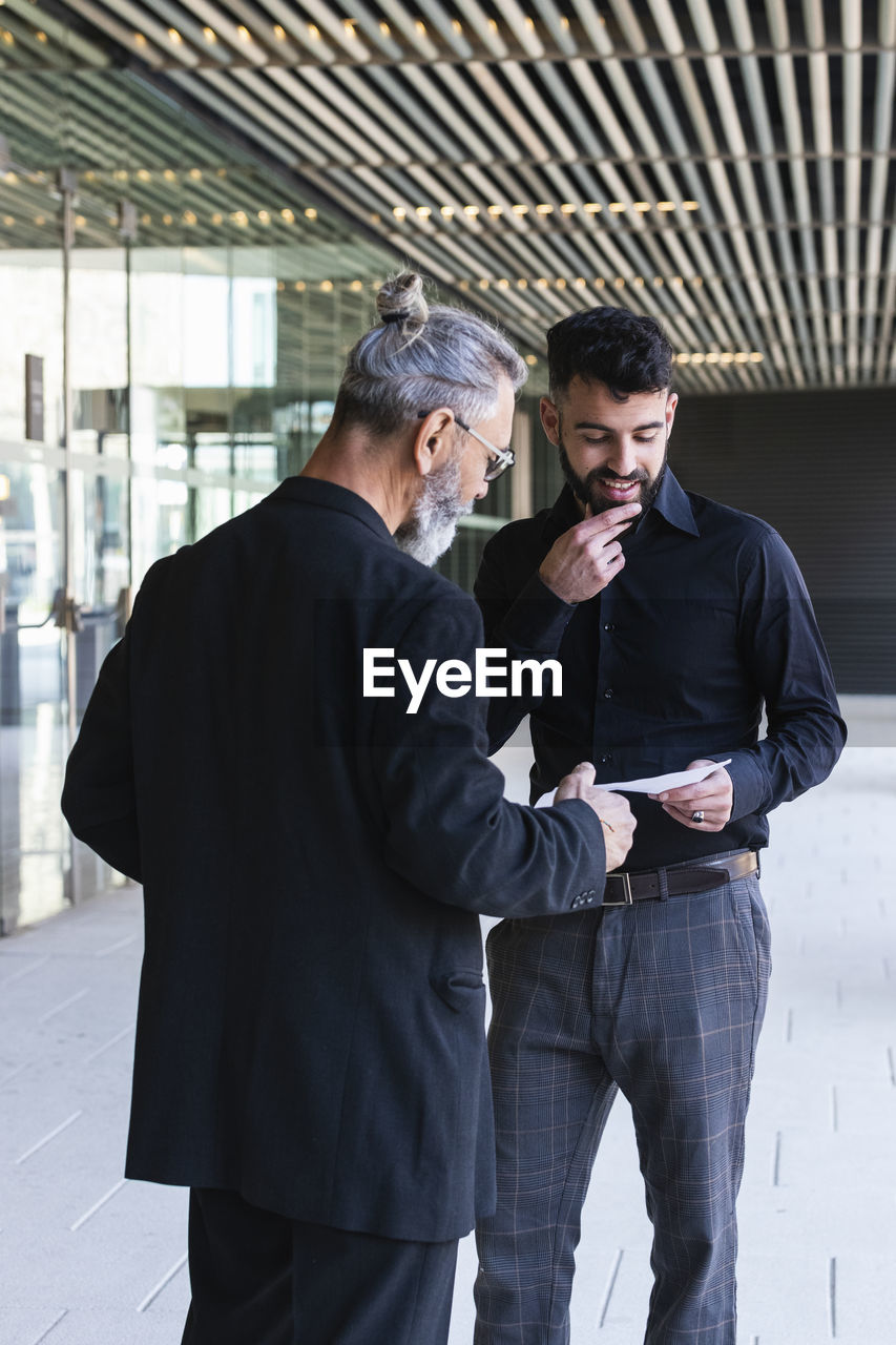 Businessmen discussing over plan on walkway