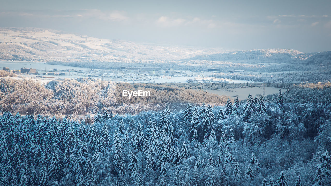 Aerial view of townscape against sky in snow