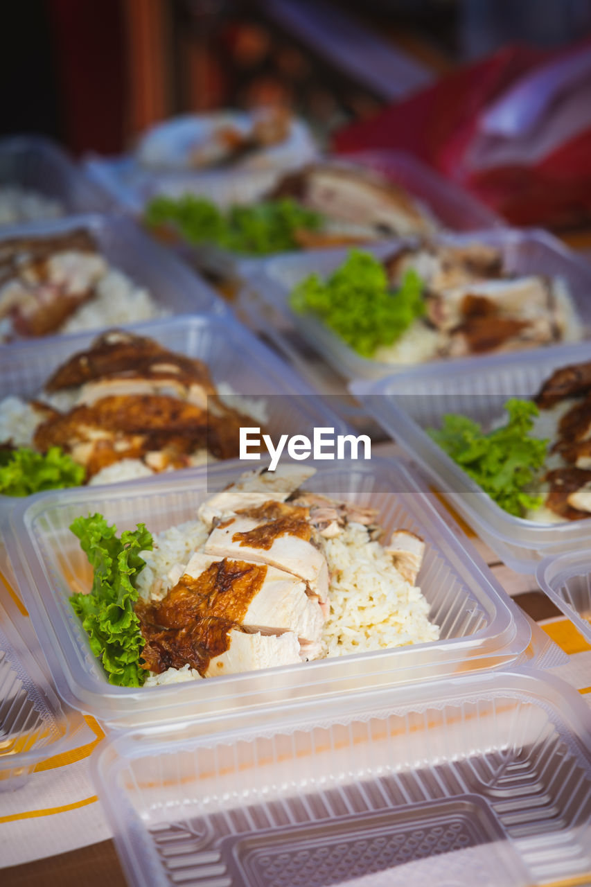  street stall or bazaar, chicken rice packed in bio degradable plastic container .