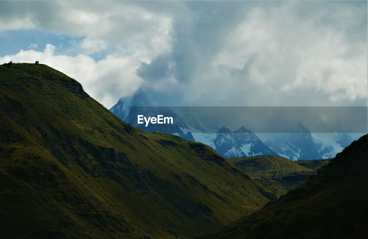 Scenic view of mountains against cloudy sky