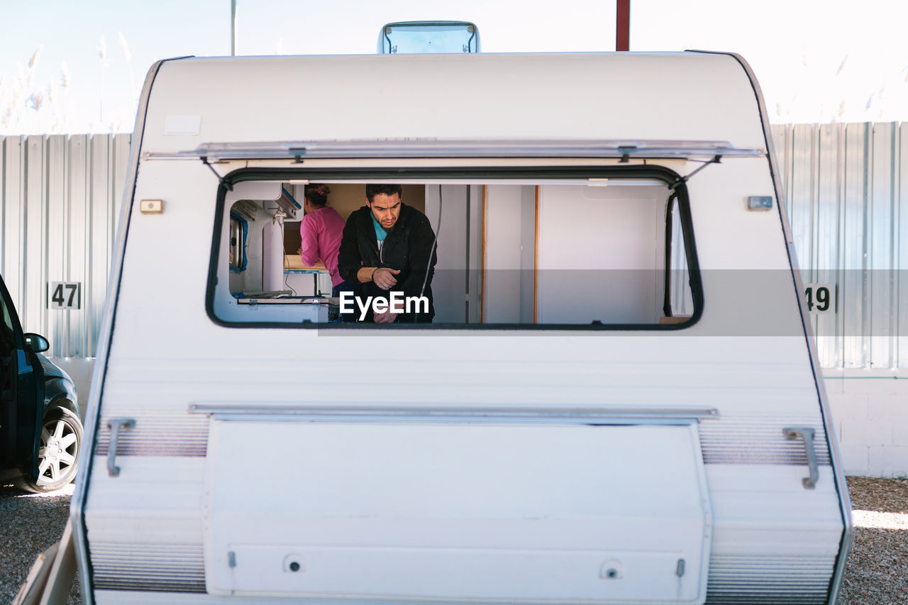 Couple seen through window of camper trailer
