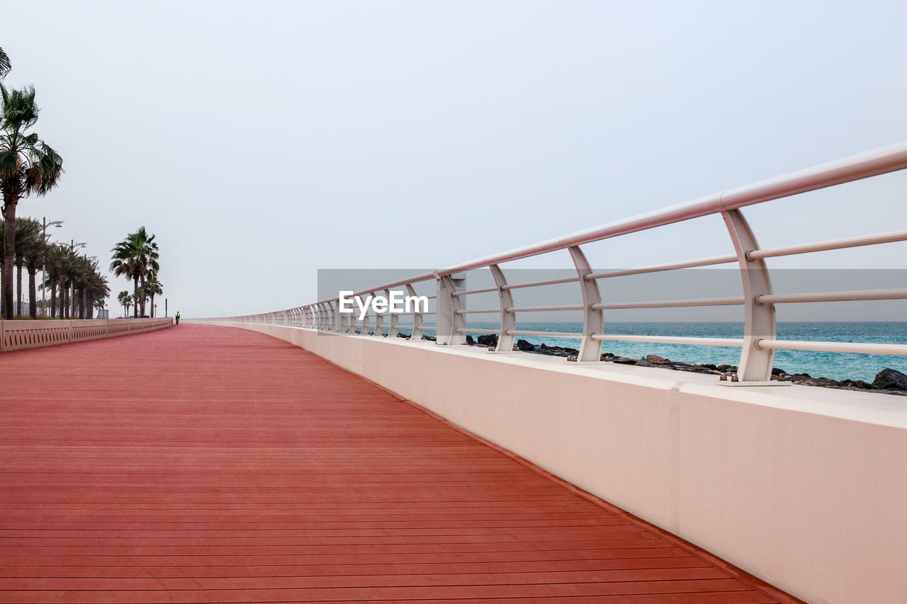 Beautiful promenade with walkway and white fence.