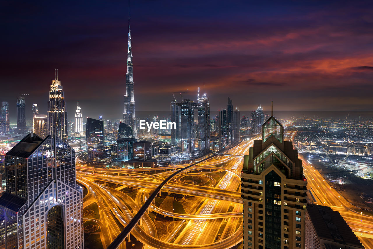 Illuminated cityscape against sky at night