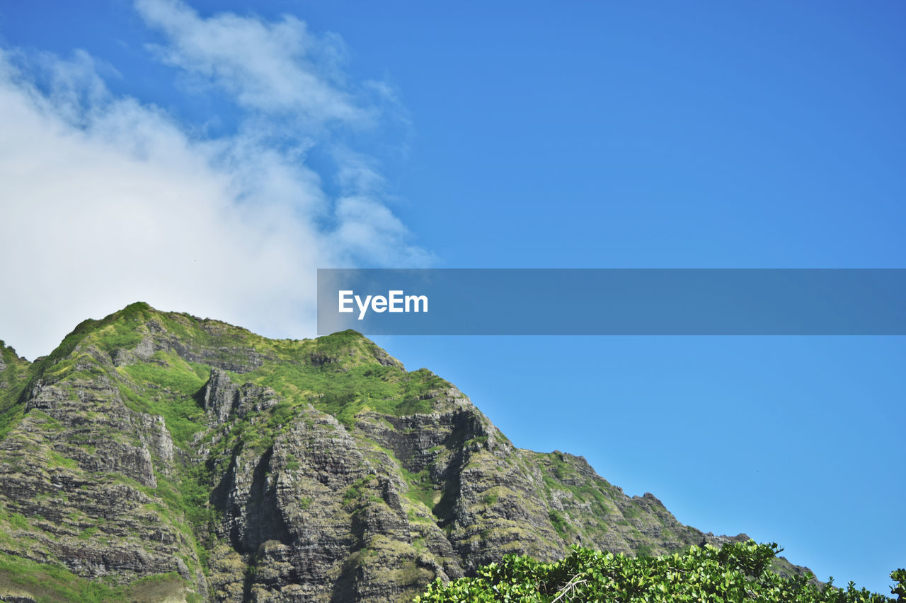 Low angle view of mountain against blue sky