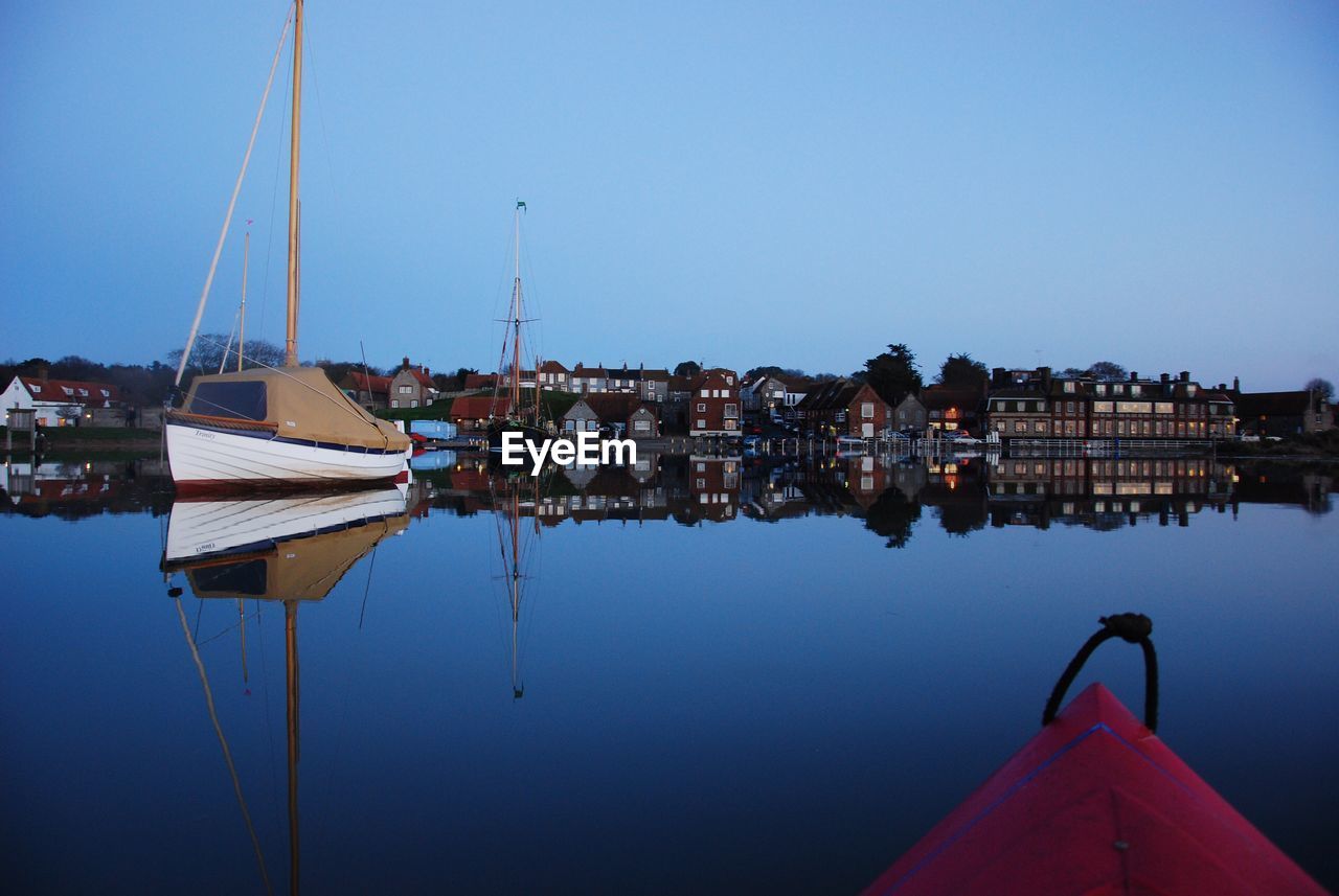 SAILBOATS MOORED ON SEA AGAINST CLEAR SKY