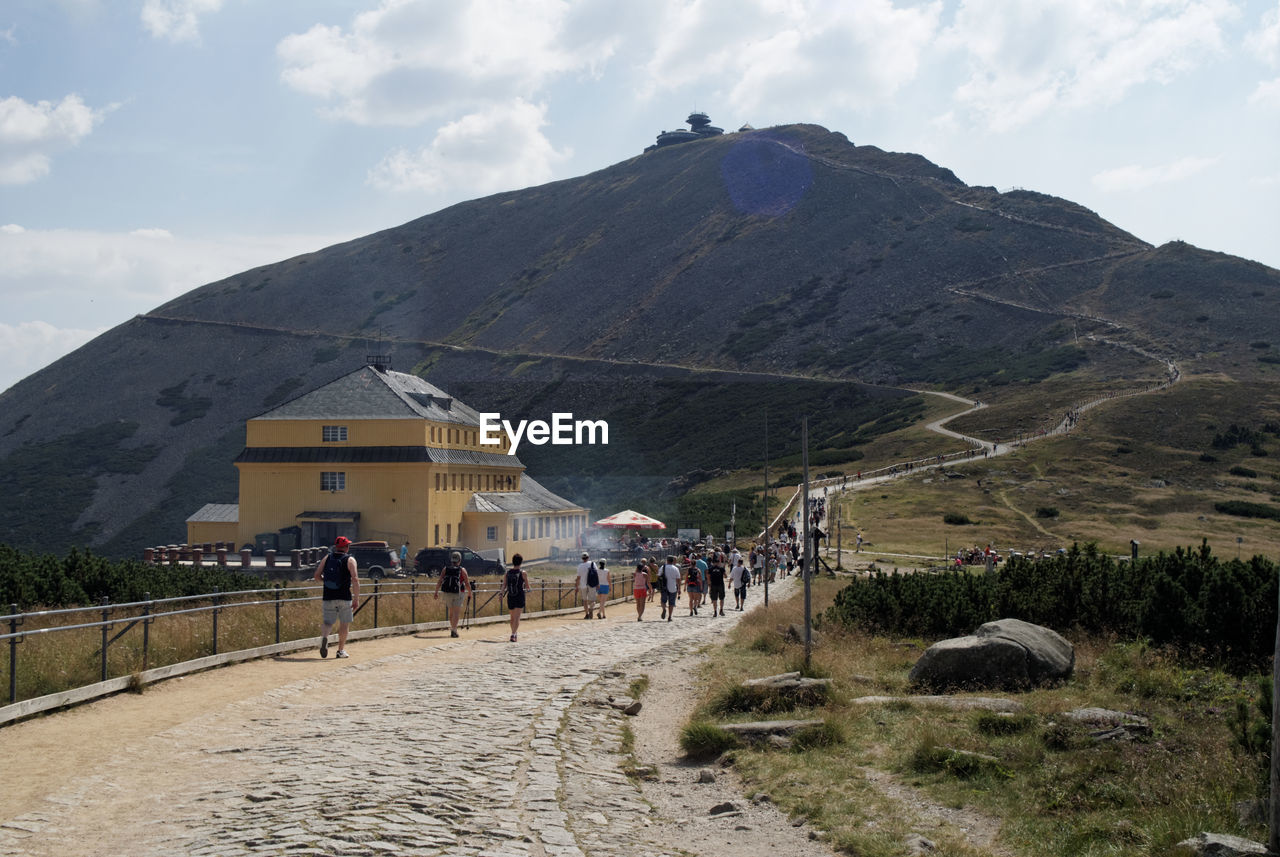 PEOPLE WALKING ON MOUNTAIN AGAINST SKY