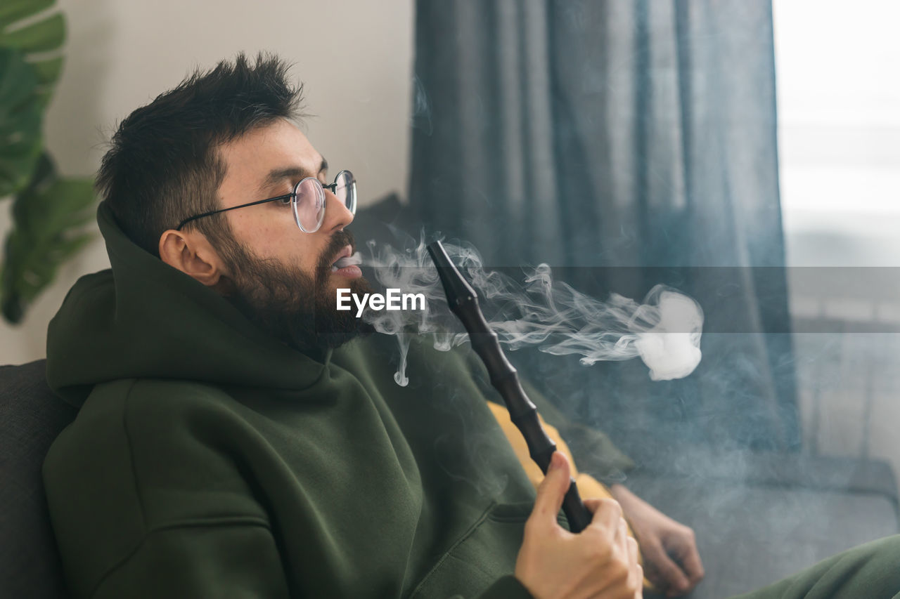 side view of man smoking electronic cigarette