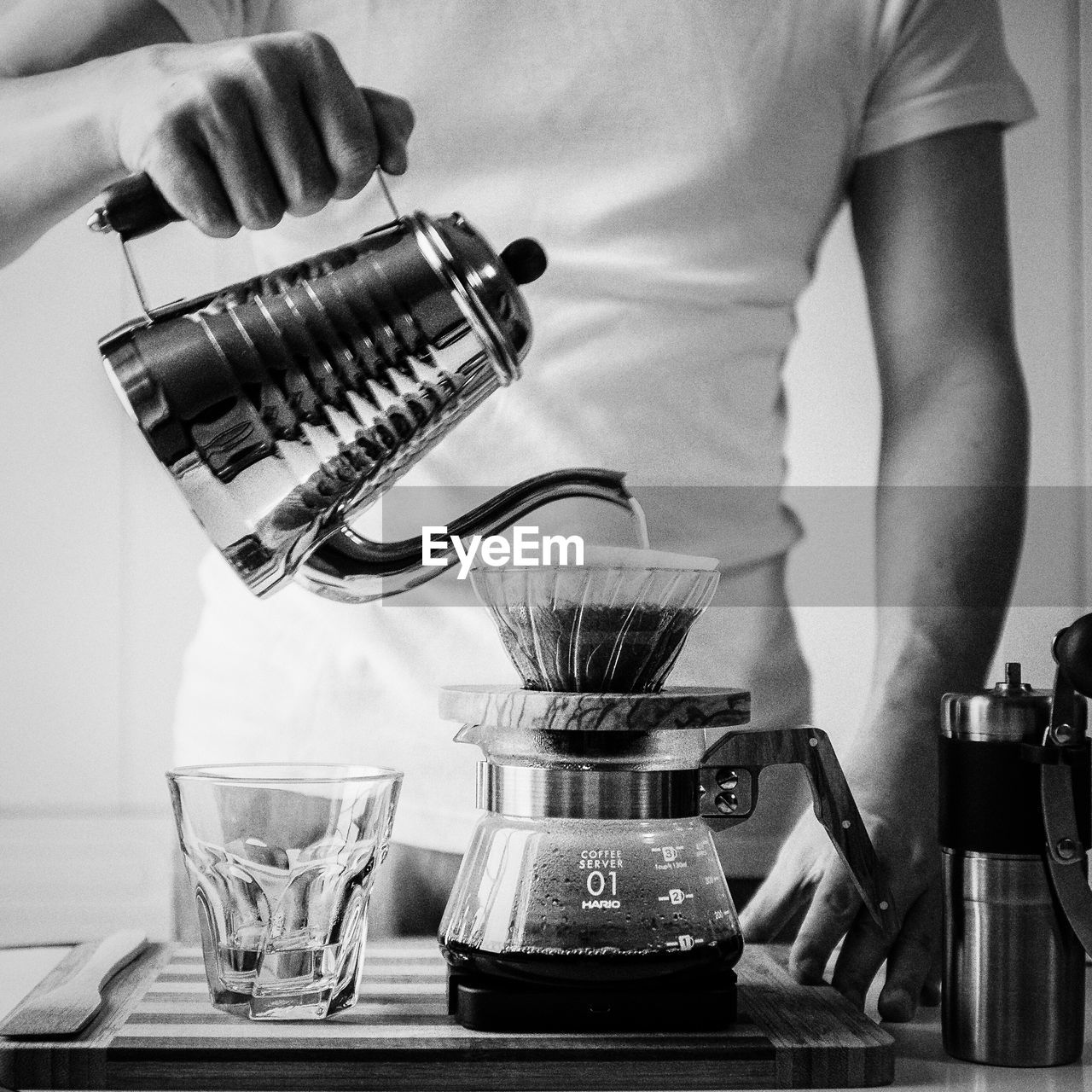 MIDSECTION OF MAN POURING COFFEE IN CUP