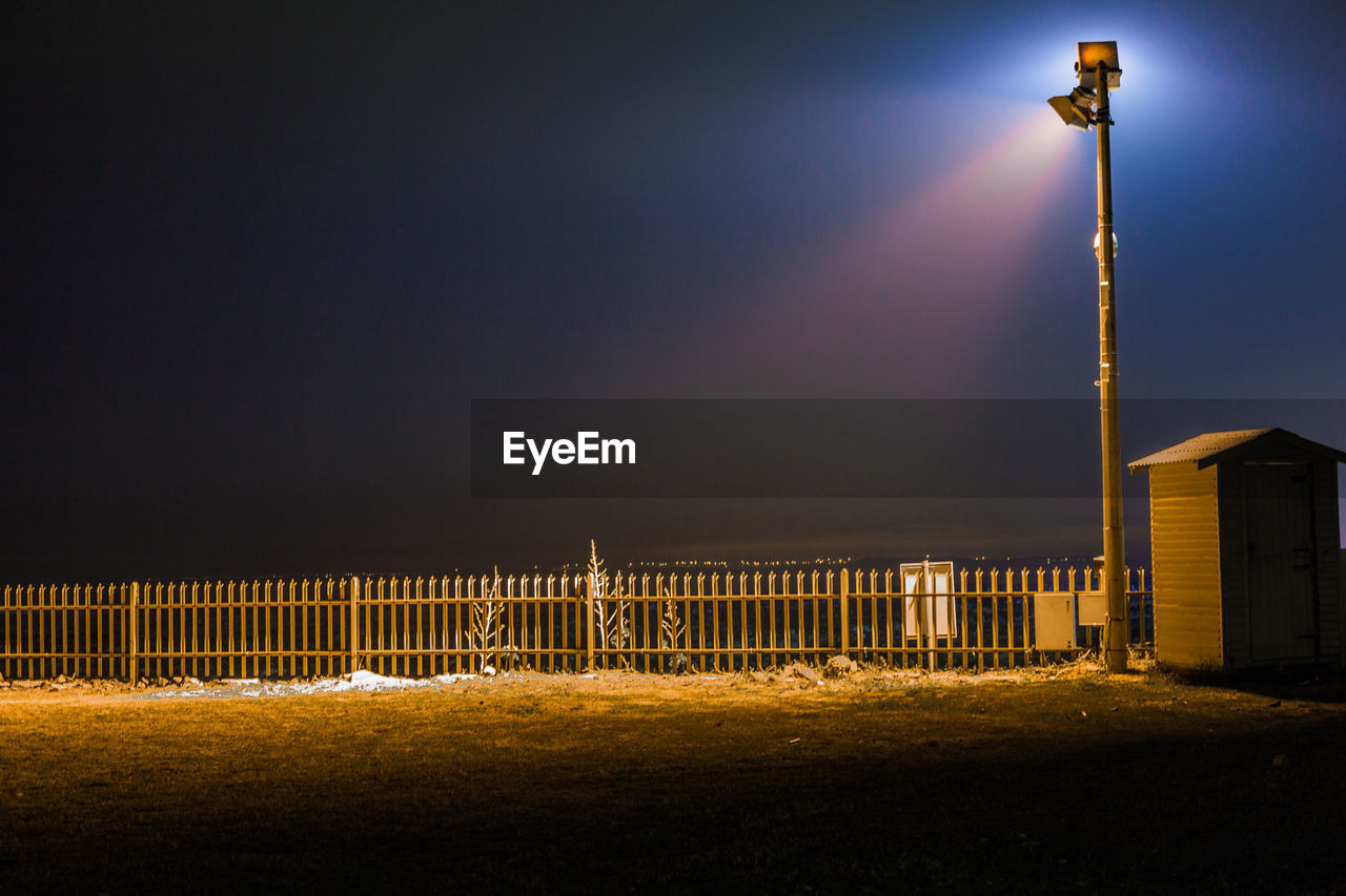 Illuminated fog against sky at night