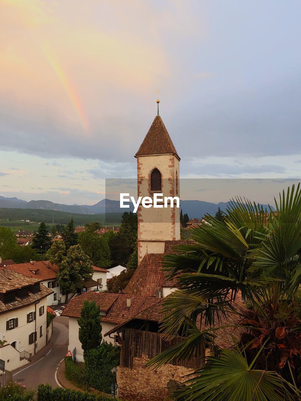 A small village in italy with a rainbow next to the church