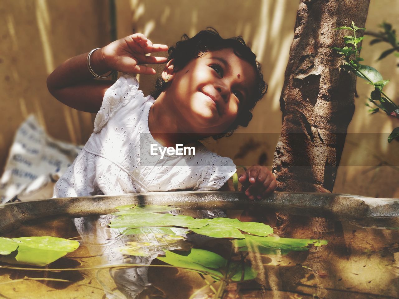 Close-up of baby girl standing by pond