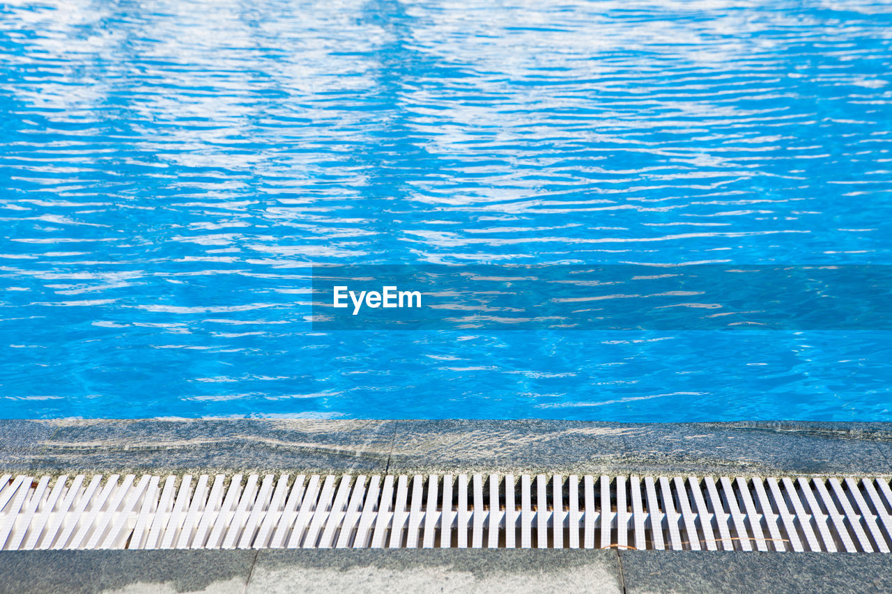 HIGH ANGLE VIEW OF SWIMMING POOL WITH SEA