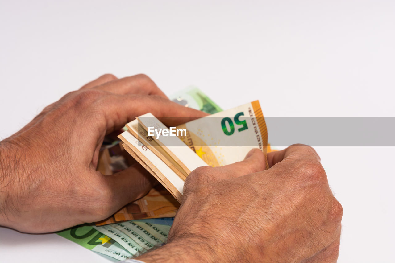 CLOSE-UP OF HUMAN HAND HOLDING PAPER