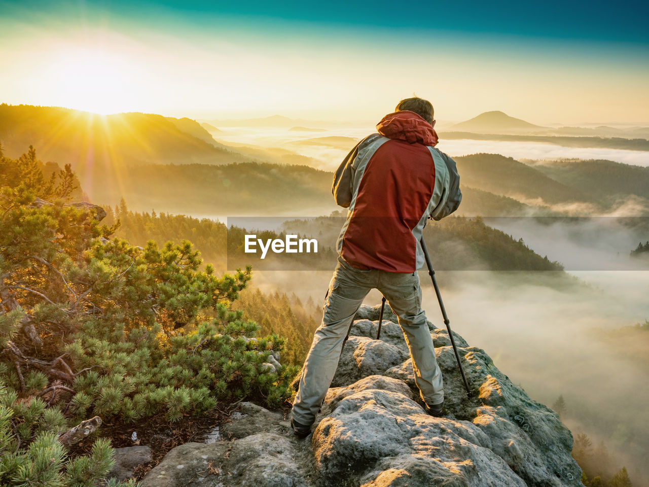 Photographer talking photos using slr camera in fall autumn forest. man photographing mountains.