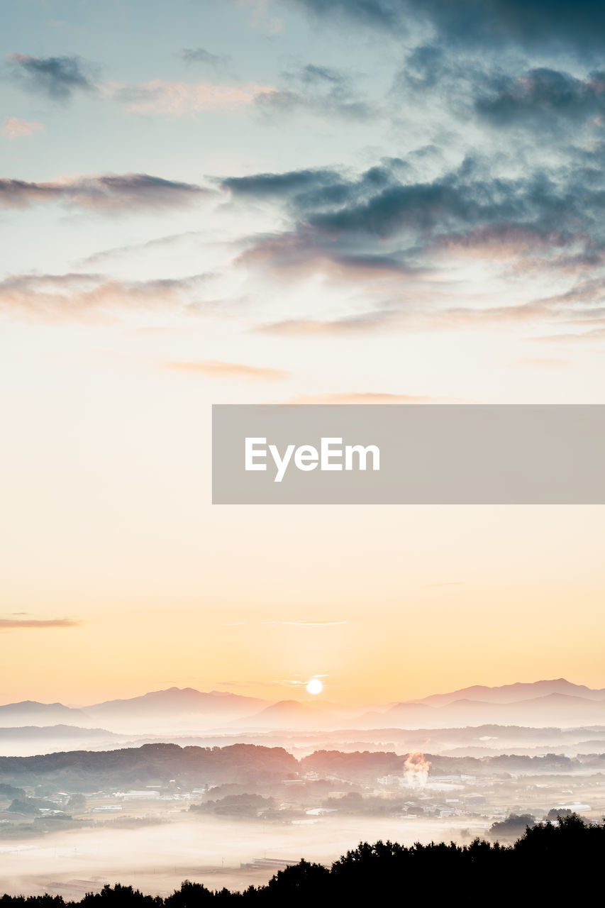 sky, beauty in nature, scenics - nature, cloud, sunset, tranquility, nature, environment, horizon, tranquil scene, landscape, dramatic sky, mountain, no people, water, land, idyllic, sea, sun, sunlight, outdoors, cloudscape, atmospheric mood, dawn, silhouette, orange color, mountain range, fog, awe, twilight, non-urban scene, moody sky, copy space, travel destinations, evening, ocean, tree, travel, afterglow