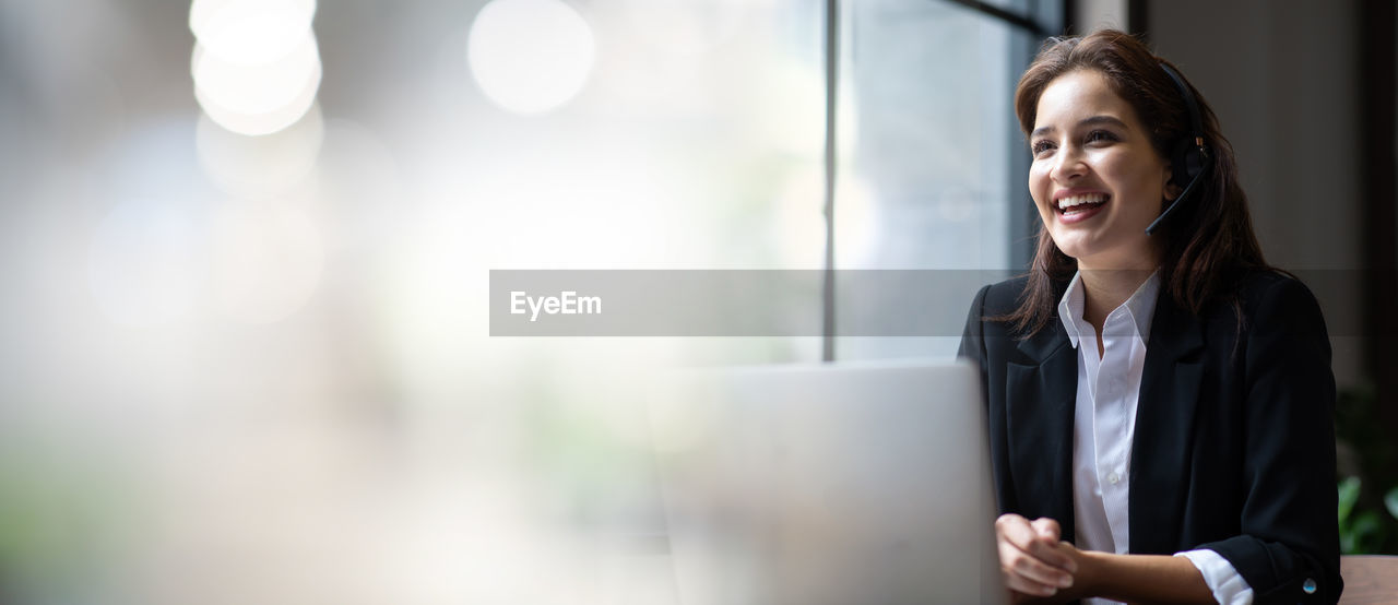 Portrait of a smiling young business woman at call center and customer service office.