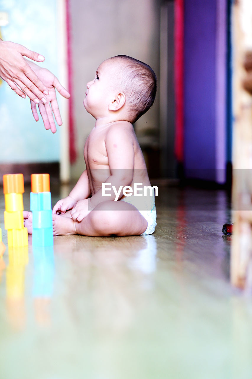 childhood, child, pink, baby, indoors, one person, skin, full length, babyhood, person, cute, innocence, toy, selective focus, flooring, emotion, sitting, toddler, baby clothing