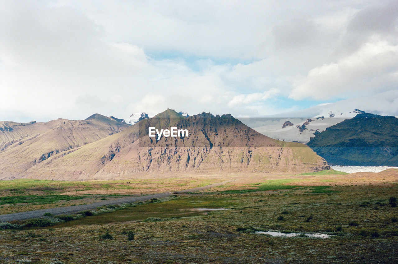 landscape, mountain, environment, scenics - nature, cloud, sky, beauty in nature, wilderness, nature, land, mountain range, highland, no people, travel destinations, lake, non-urban scene, travel, grass, snow, tranquil scene, plateau, tranquility, day, ridge, outdoors, cold temperature, plant, tourism, plain, volcano, snowcapped mountain, winter, grassland, rock, water, valley, geology, remote