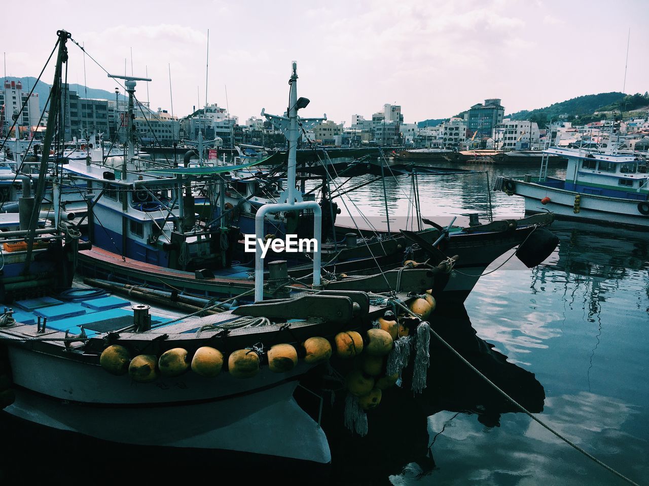 Fishing boats moored at harbor in city