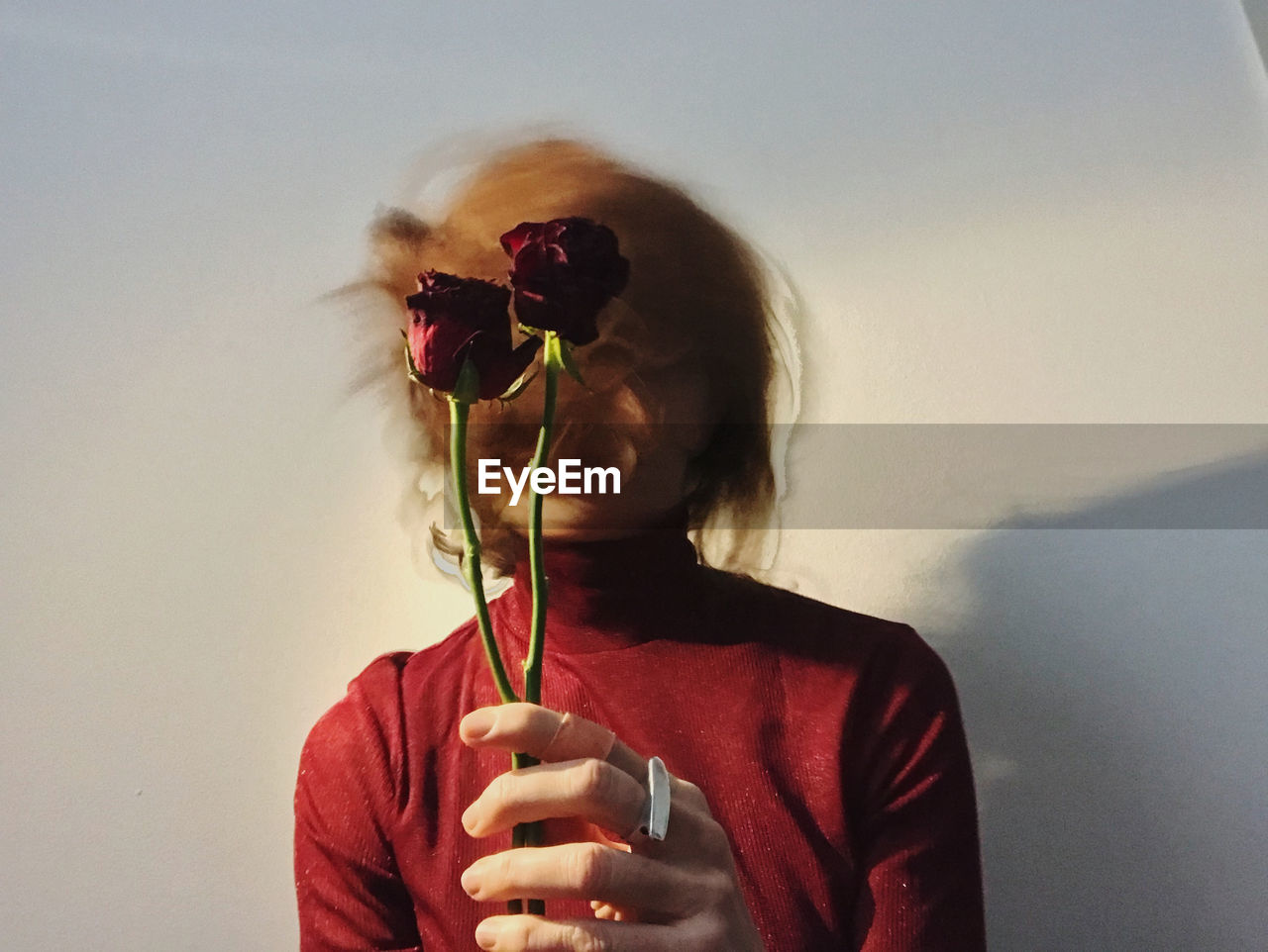 Portrait of young woman in motion with flowers and red shirt