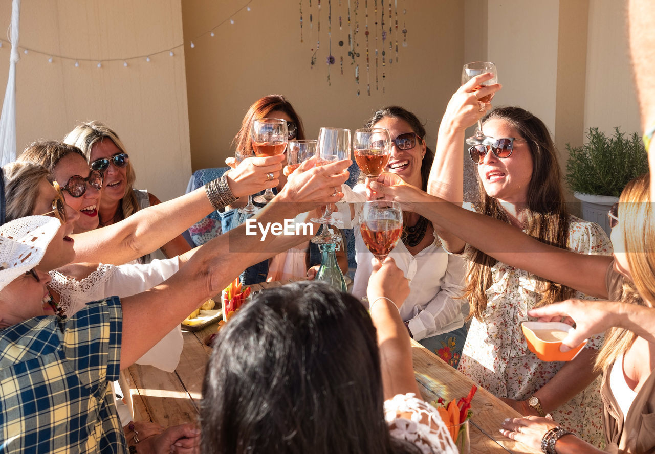 Female friends doing celebratory toast at building terrace