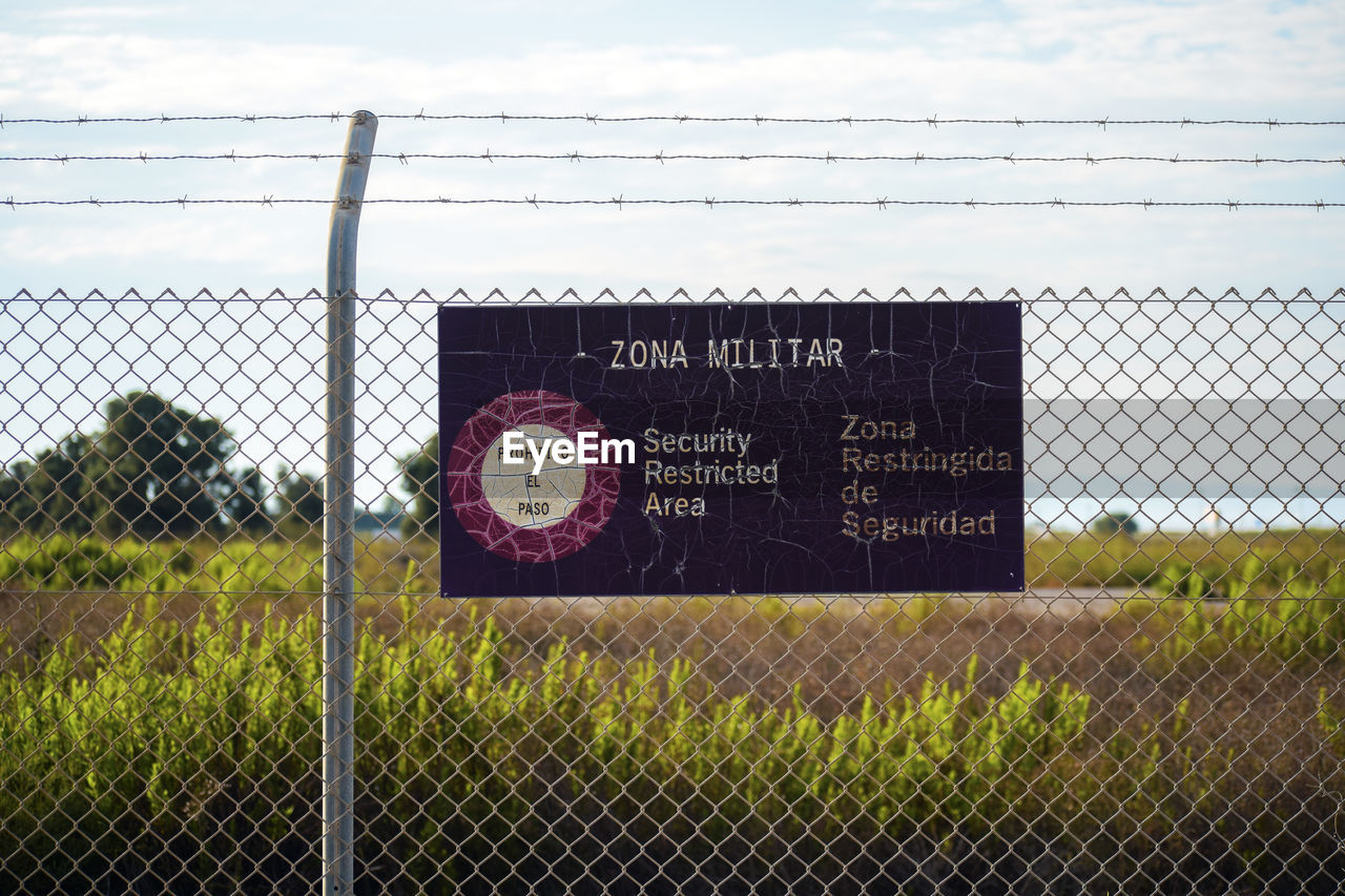 TEXT ON FENCE AGAINST SKY